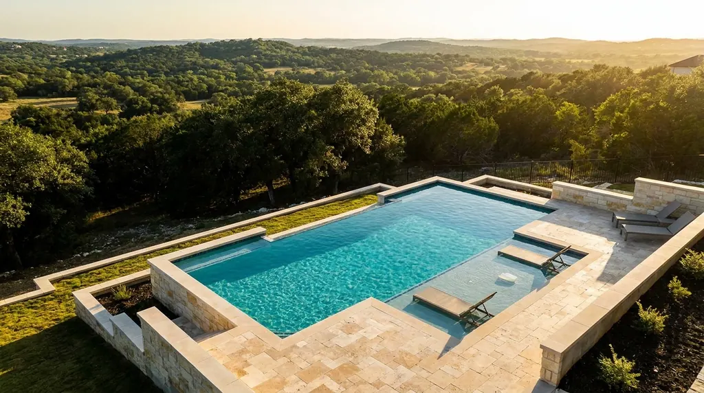 Geometric pool with a travertine deck and limestone walls overlooking the Texas Hill Country